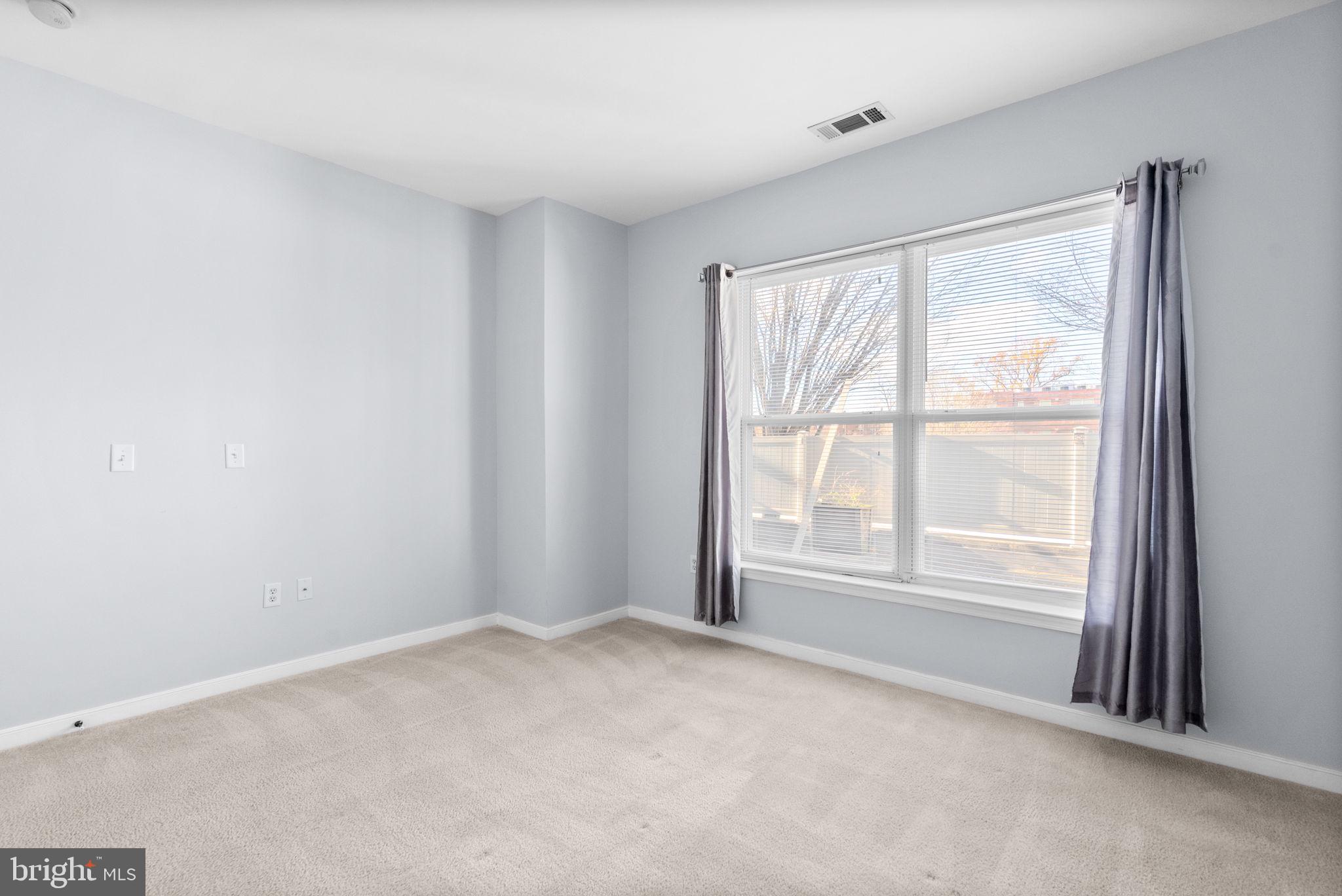 8045 Newell Street, Unit 116 Silver Spring, MD 20910 - Photo 16 of 28 an empty room with windows