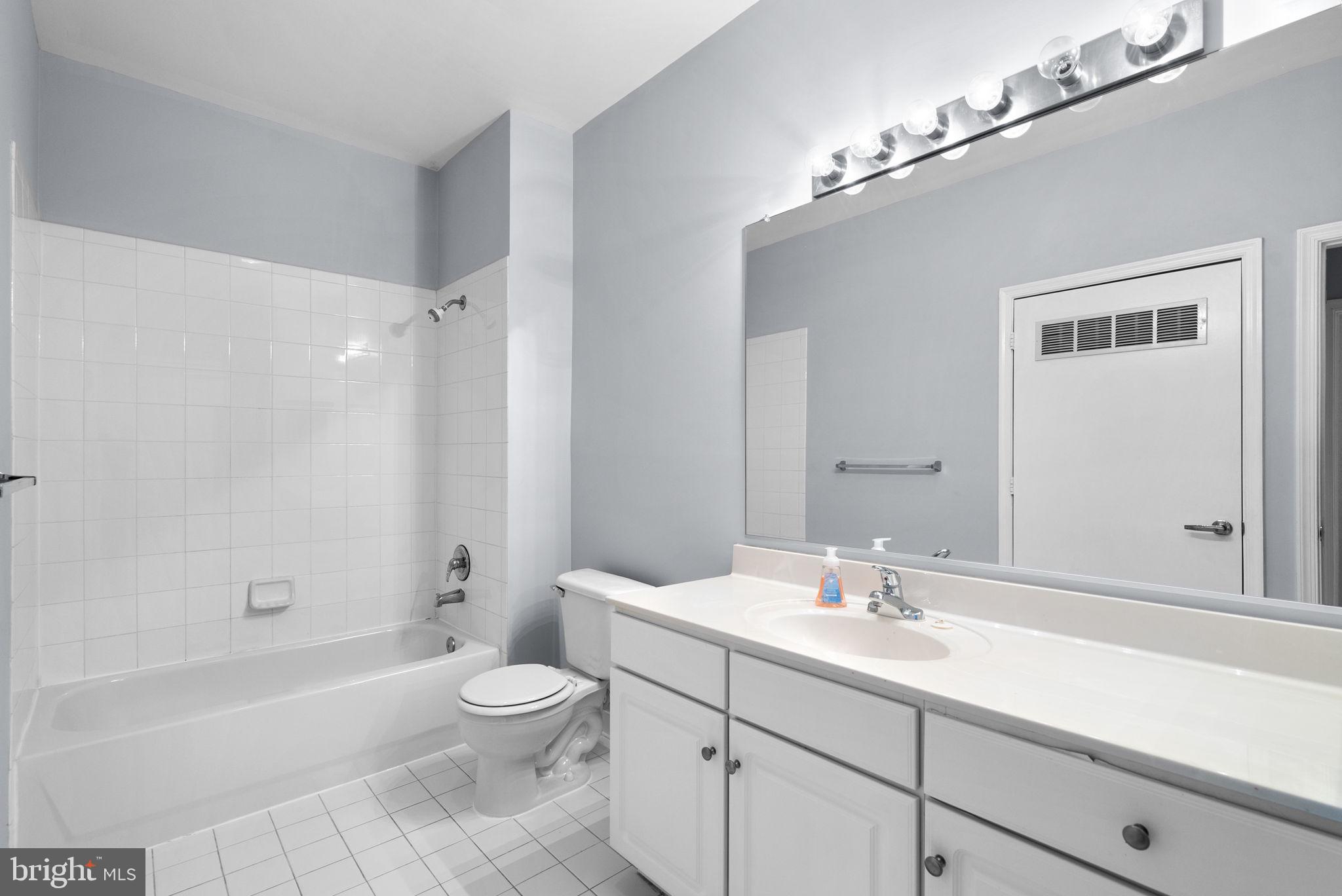 8045 Newell Street, Unit 116 Silver Spring, MD 20910 - Photo 19 of 28 a bathroom with a sink a toilet and a large mirror