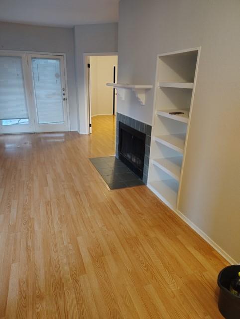 a view of empty room with wooden floor and fireplace