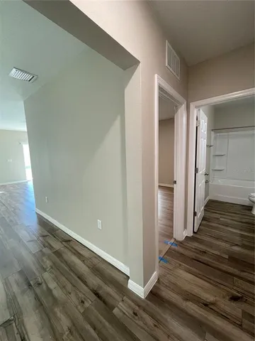a view of a hallway with wooden floor and staircase