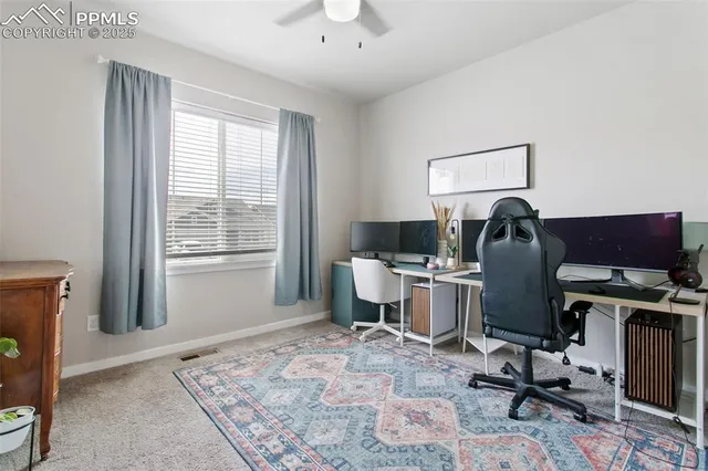a view of a workspace with furniture and a window