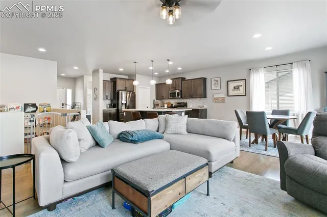 a living room with furniture and a view of kitchen