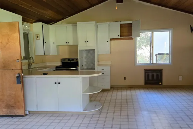 a view of a house with a big yard and large trees