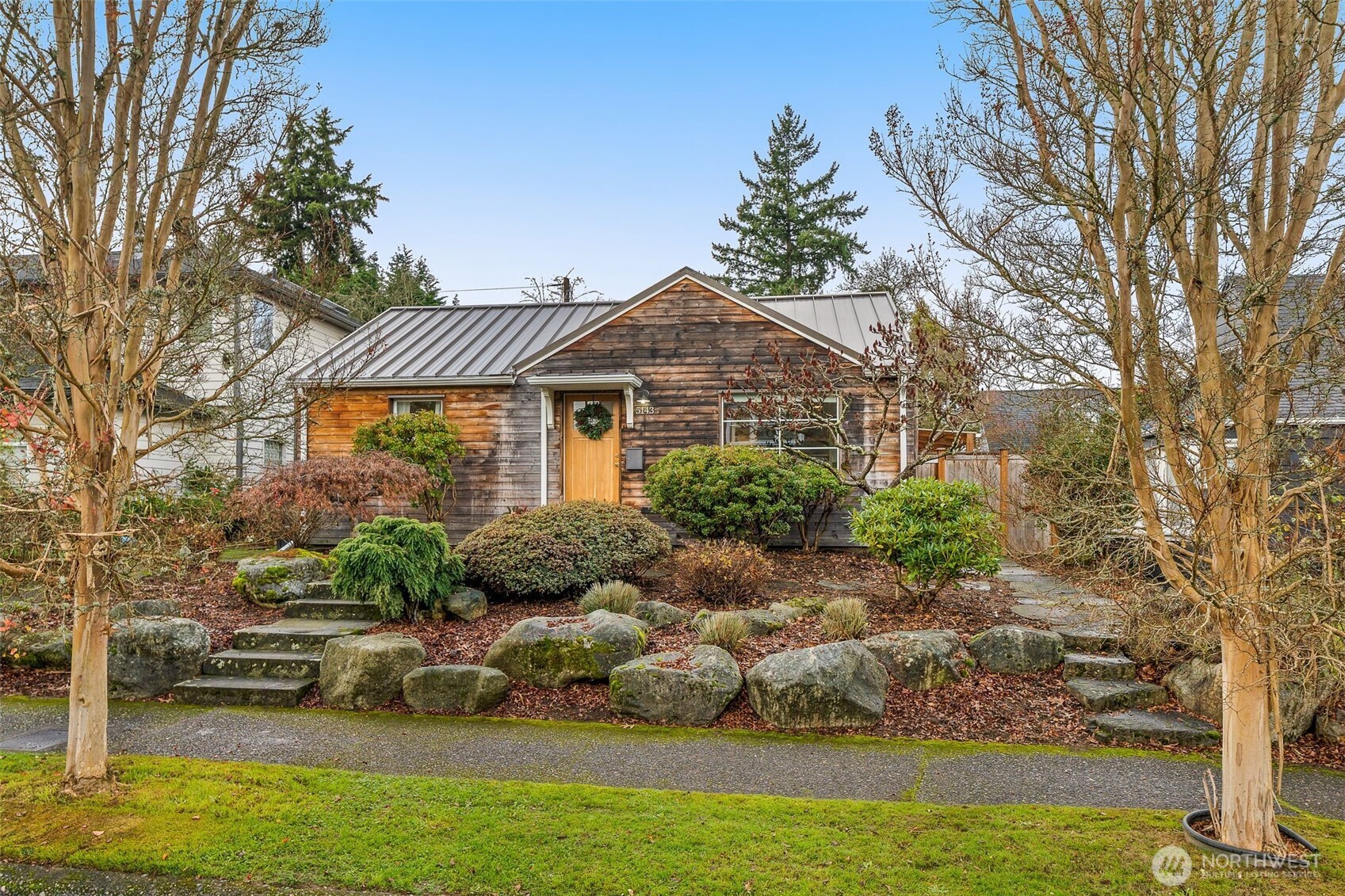 a front view of a house with a yard and lake view