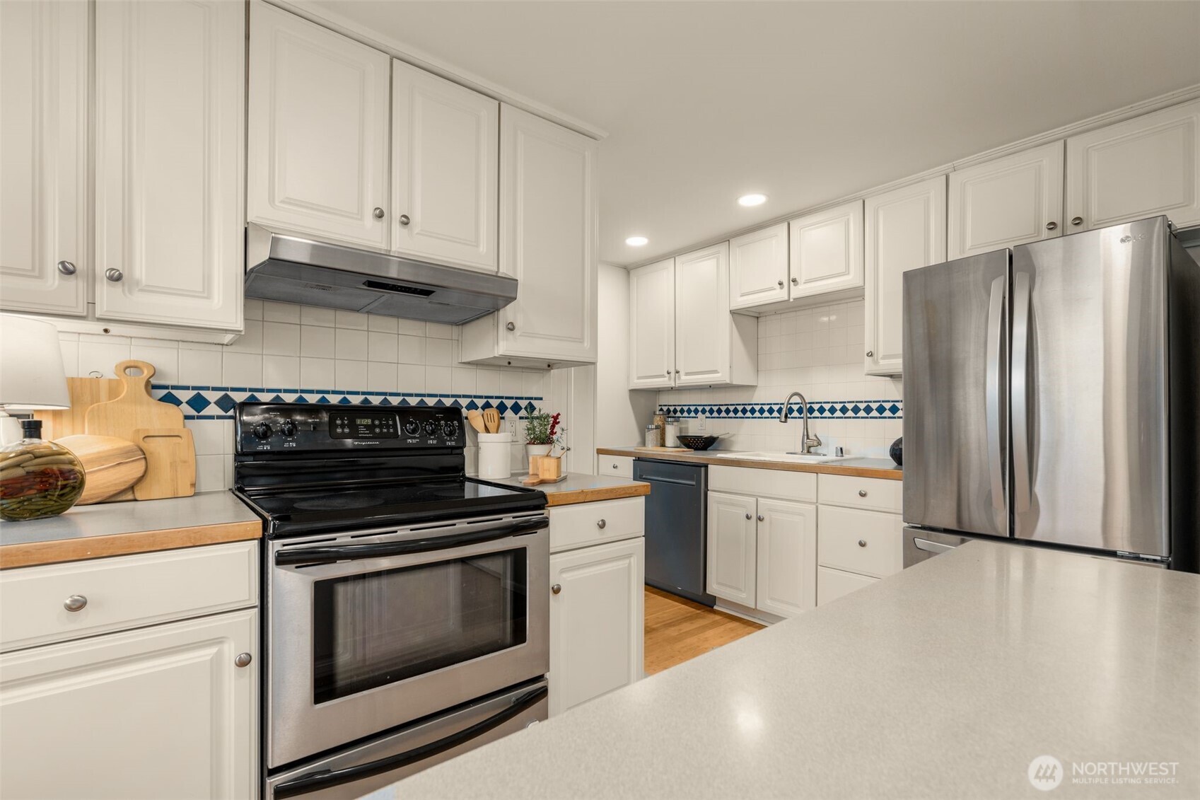 5143 46th Avenue Northeast Seattle, WA 98105 - Photo 5 of 33 a kitchen with granite countertop white cabinets and stainless steel appliances