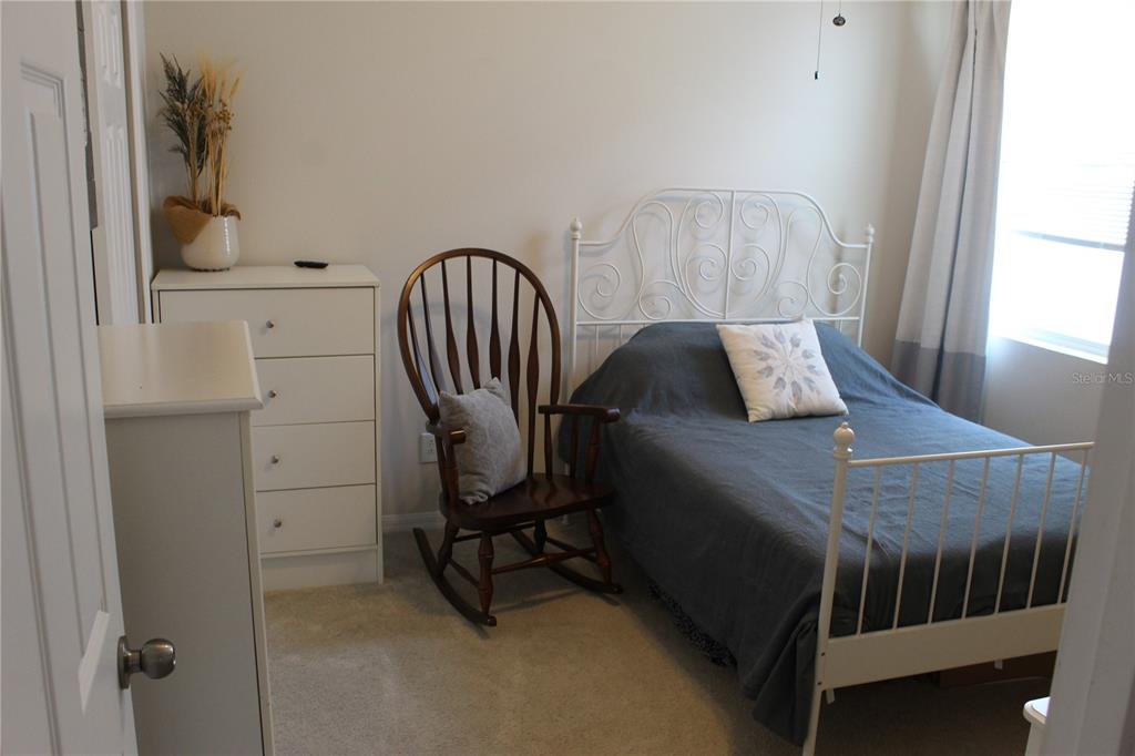 4110 Arlington Ridge Boulevard Leesburg, FL 34748 - Photo 13 of 33 a bedroom with a bed a table and chair