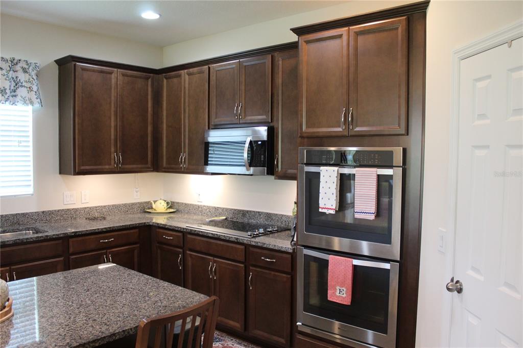 4110 Arlington Ridge Boulevard Leesburg, FL 34748 - Photo 5 of 33 a kitchen with stainless steel appliances granite countertop wooden cabinets and a counter top space
