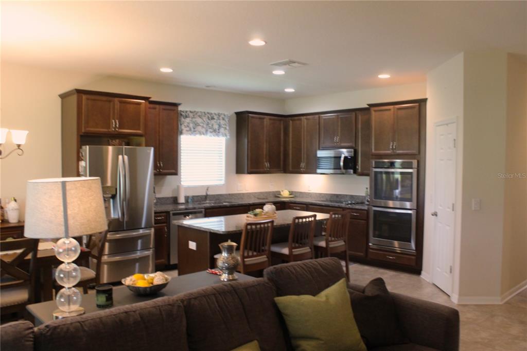 4110 Arlington Ridge Boulevard Leesburg, FL 34748 - Photo 7 of 33 a kitchen with stainless steel appliances granite countertop a refrigerator stove top oven and sink