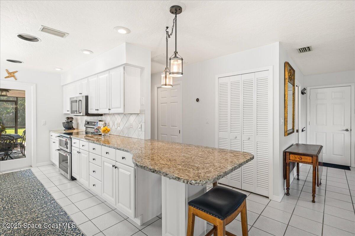 3651 Big Pine Road Melbourne, FL 32934 - Photo 13 of 32 a kitchen with granite countertop a sink cabinets and wooden floor