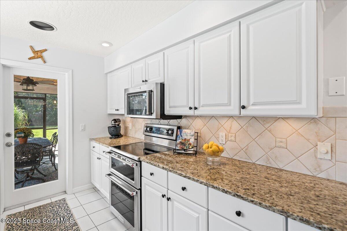 3651 Big Pine Road Melbourne, FL 32934 - Photo 15 of 32 a kitchen with stainless steel appliances granite countertop a stove a sink and a white cabinets