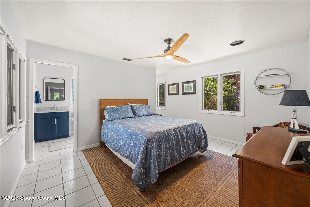 3651 Big Pine Road Melbourne, FL 32934 - Photo 16 of 32 a bedroom with a large bed and a chandelier
