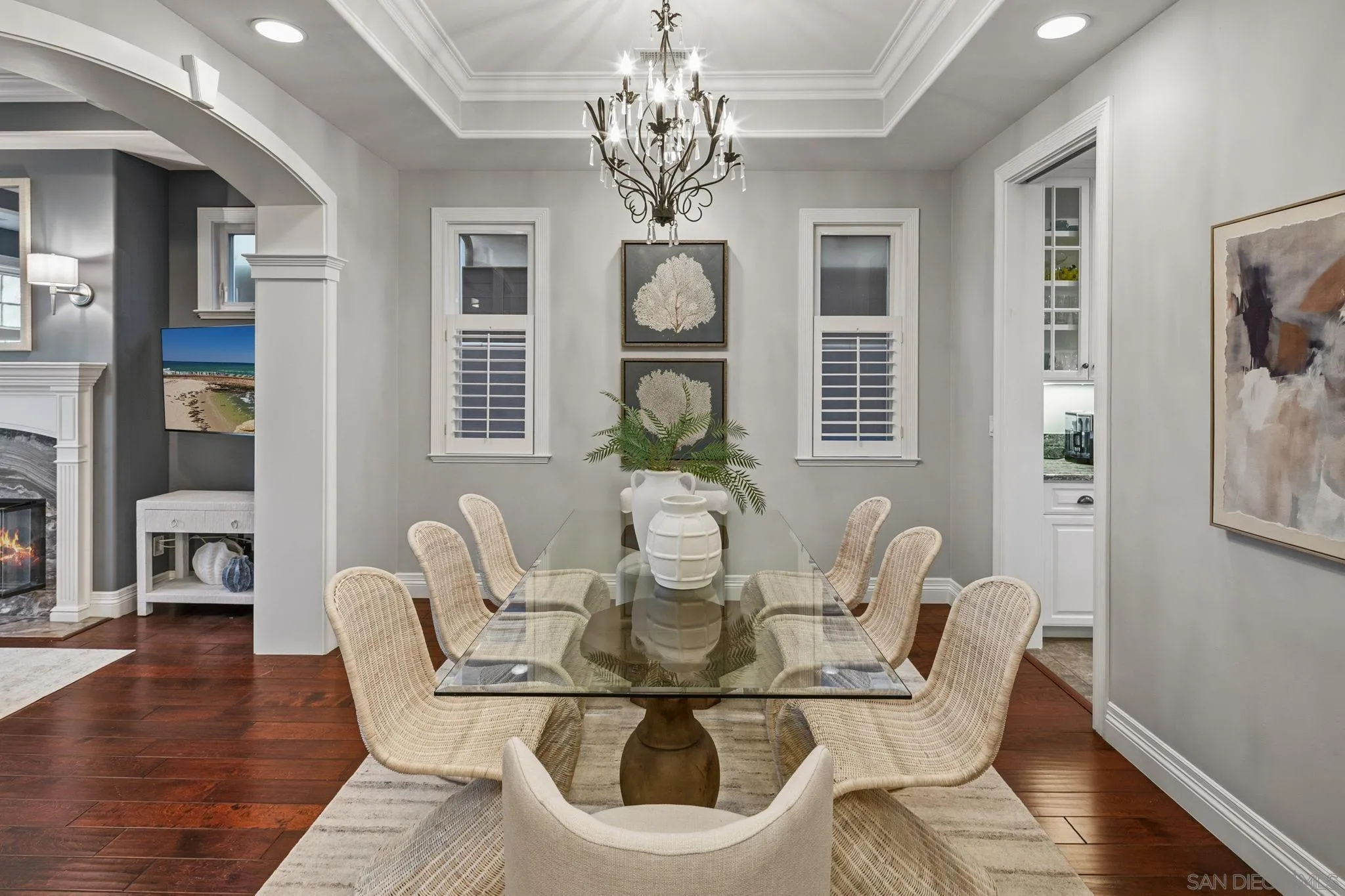 861 B Avenue Coronado, CA 92118 - Photo 11 of 45 a dining room with wooden floor a chandelier a glass table and chairs