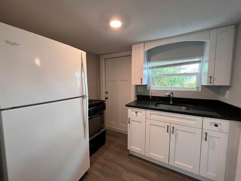 718 West 7th Street, Unit 2 Riviera Beach, FL 33404 - Photo 11 of 21 a kitchen with granite countertop white cabinets and white appliances