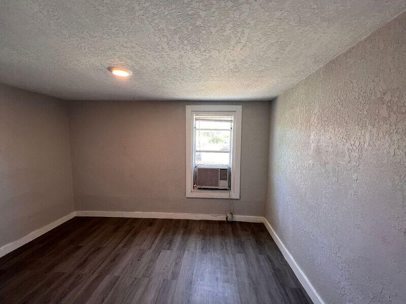 718 West 7th Street, Unit 2 Riviera Beach, FL 33404 - Photo 13 of 21 an empty room with wooden floor and windows