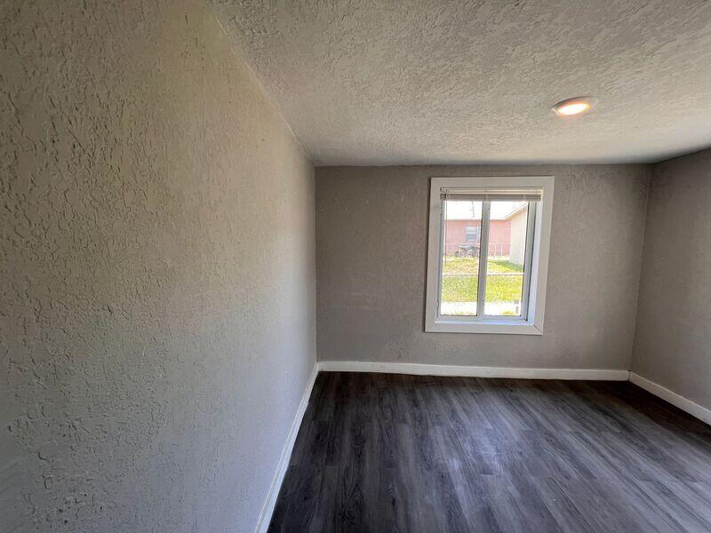 718 West 7th Street, Unit 2 Riviera Beach, FL 33404 - Photo 15 of 21 an empty room with wooden floor and windows