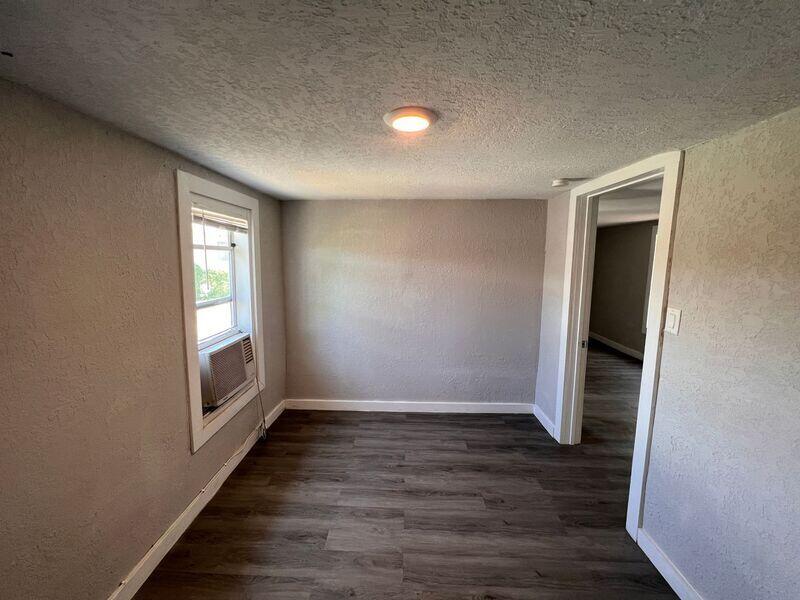 718 West 7th Street, Unit 2 Riviera Beach, FL 33404 - Photo 17 of 21 an empty room with wooden floor and windows