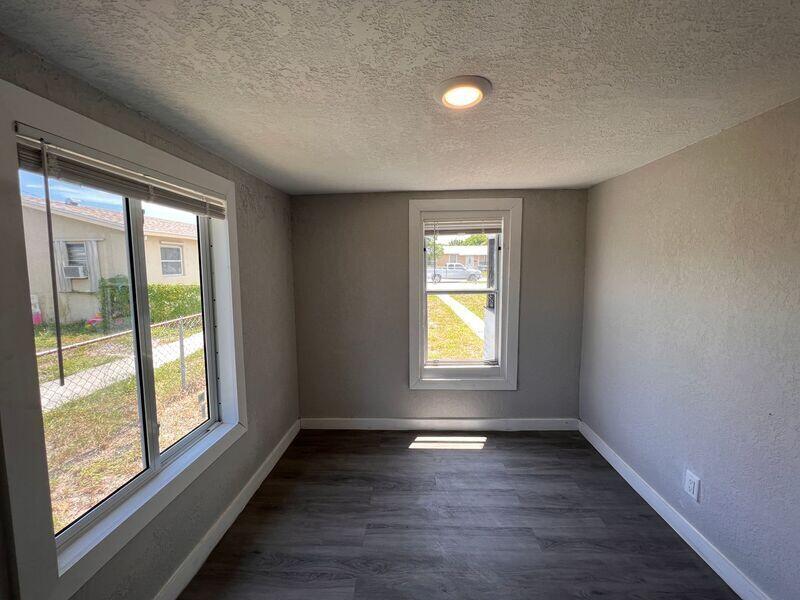 718 West 7th Street, Unit 2 Riviera Beach, FL 33404 - Photo 19 of 21 an empty room with wooden floor and windows