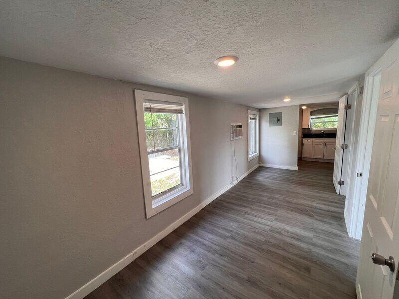 718 West 7th Street, Unit 2 Riviera Beach, FL 33404 - Photo 5 of 21 an empty room with wooden floor and windows