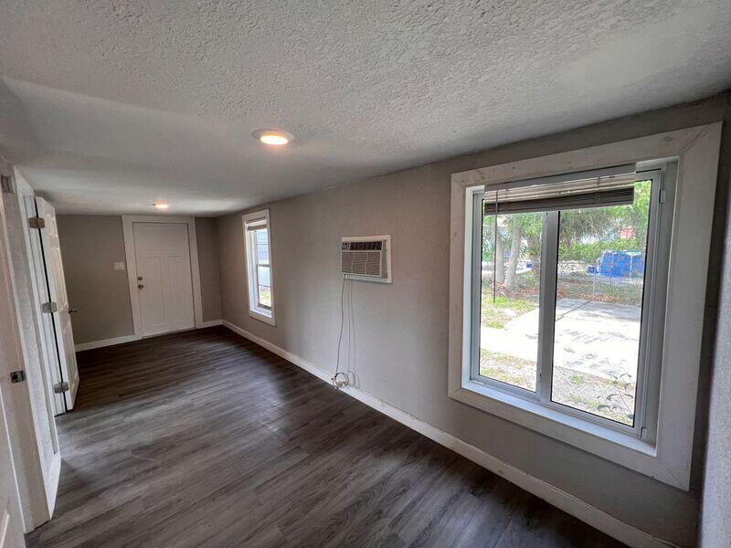 718 West 7th Street, Unit 2 Riviera Beach, FL 33404 - Photo 7 of 21 an empty room with wooden floor and windows