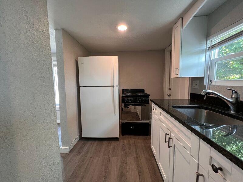 718 West 7th Street, Unit 2 Riviera Beach, FL 33404 - Photo 10 of 21 a kitchen with granite countertop stainless steel appliances a refrigerator a sink a stove and a refrigerator