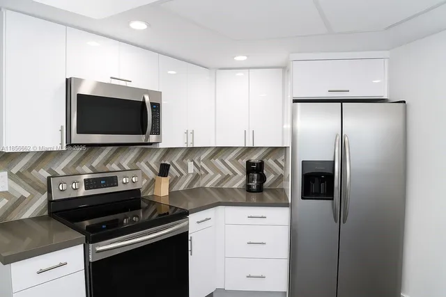 a kitchen with a refrigerator and a stove top oven