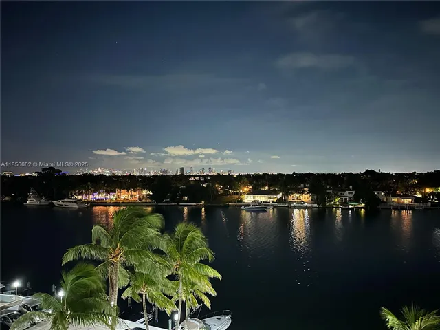 a view of lake with boats and trees in the background