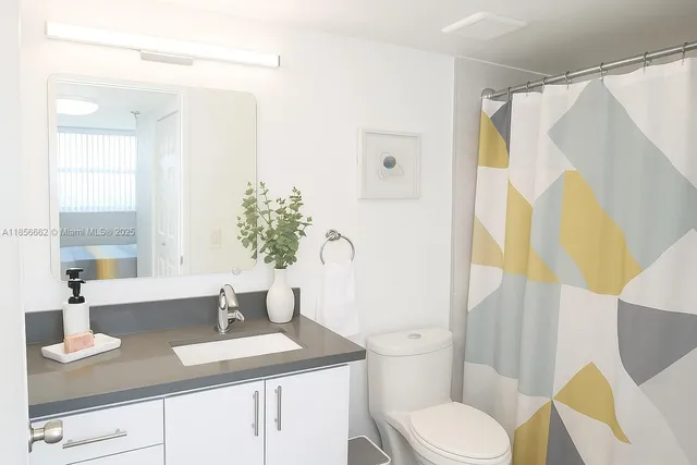 a bathroom with a granite countertop sink toilet and shower
