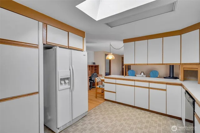 a kitchen with a refrigerator a sink and cabinets