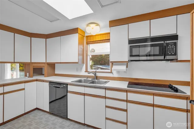 a kitchen with stainless steel appliances a sink a stove and cabinets