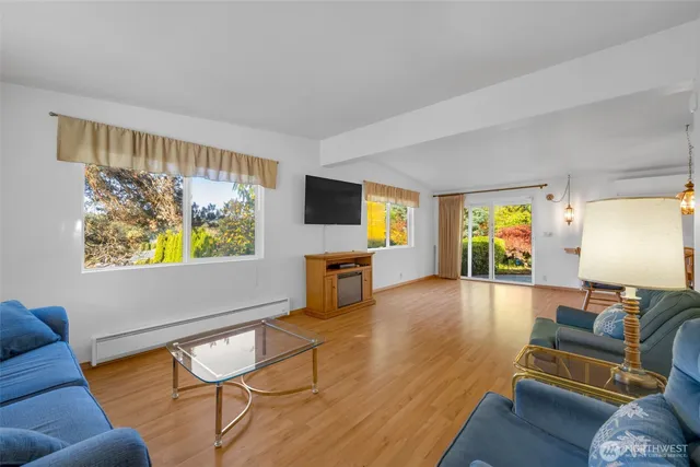 a living room with furniture and a flat screen tv with wooden floor