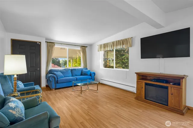 a living room with furniture a flat screen tv and a fireplace