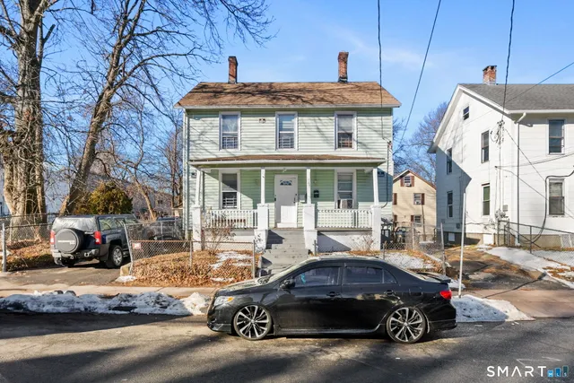 a car parked in front of a brick house