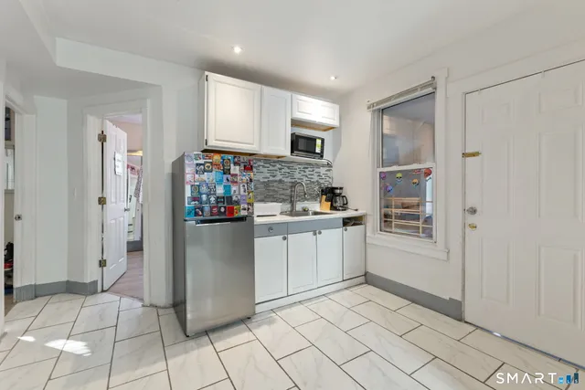 a kitchen with a refrigerator and white cabinets