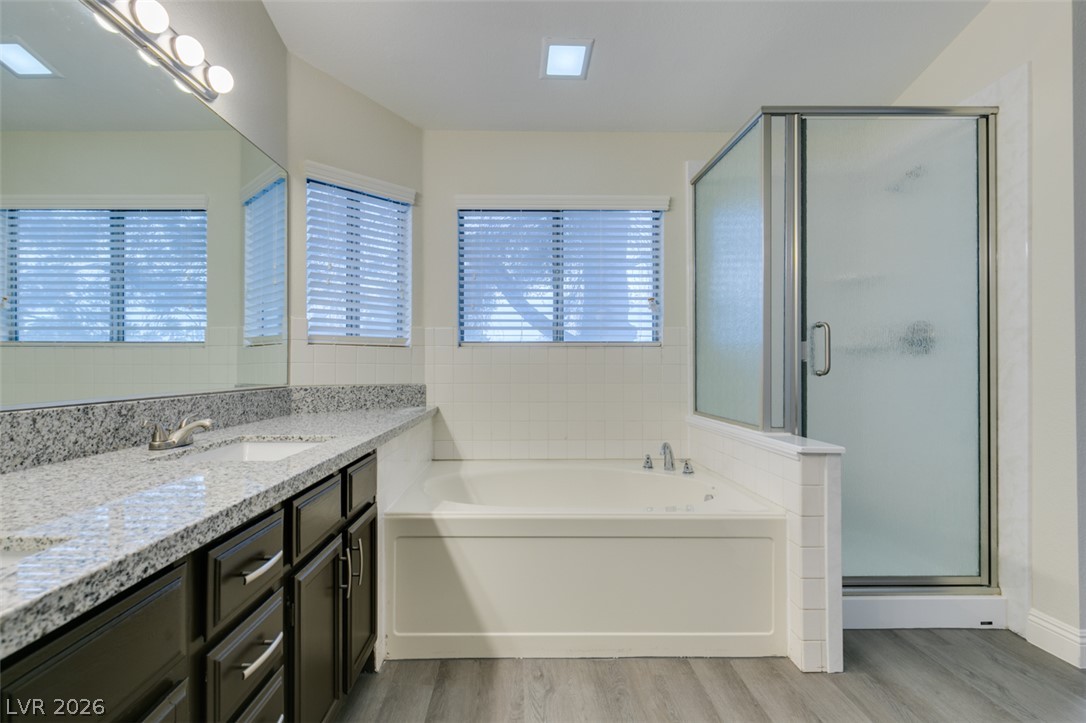 1738 Toltec Circle Henderson, NV 89014 - Photo 33 of 46 Granite counters and dual sinks define this serene primary bathroom, complete with a separate shower and soaking tub.
