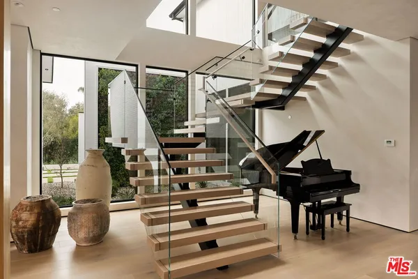 a living room with furniture a flat screen tv and floor to ceiling window