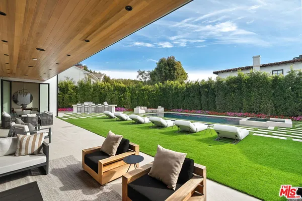 a view of a patio with couches table and chairs with wooden fence