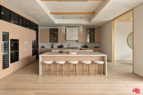 a large kitchen with kitchen island a stove a sink a dining table and chairs