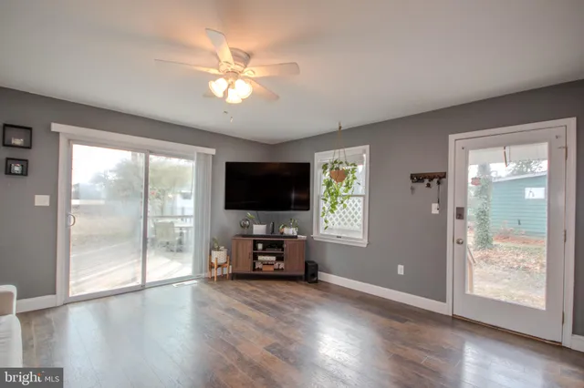 a view of a livingroom with wooden floor and a flat screen tv