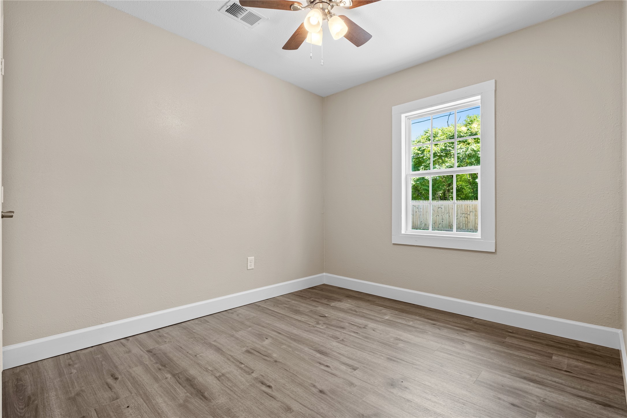 6119 Beekman Road Houston, TX 77021 - Photo 18 of 20 an empty room with wooden floor and windows