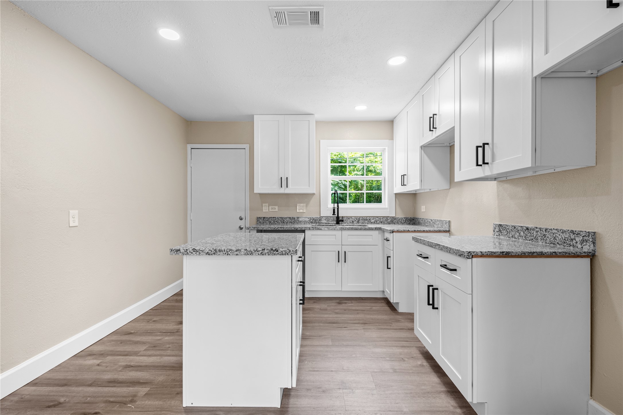 6119 Beekman Road Houston, TX 77021 - Photo 9 of 20 a kitchen with granite countertop cabinets stainless steel appliances a sink and a window