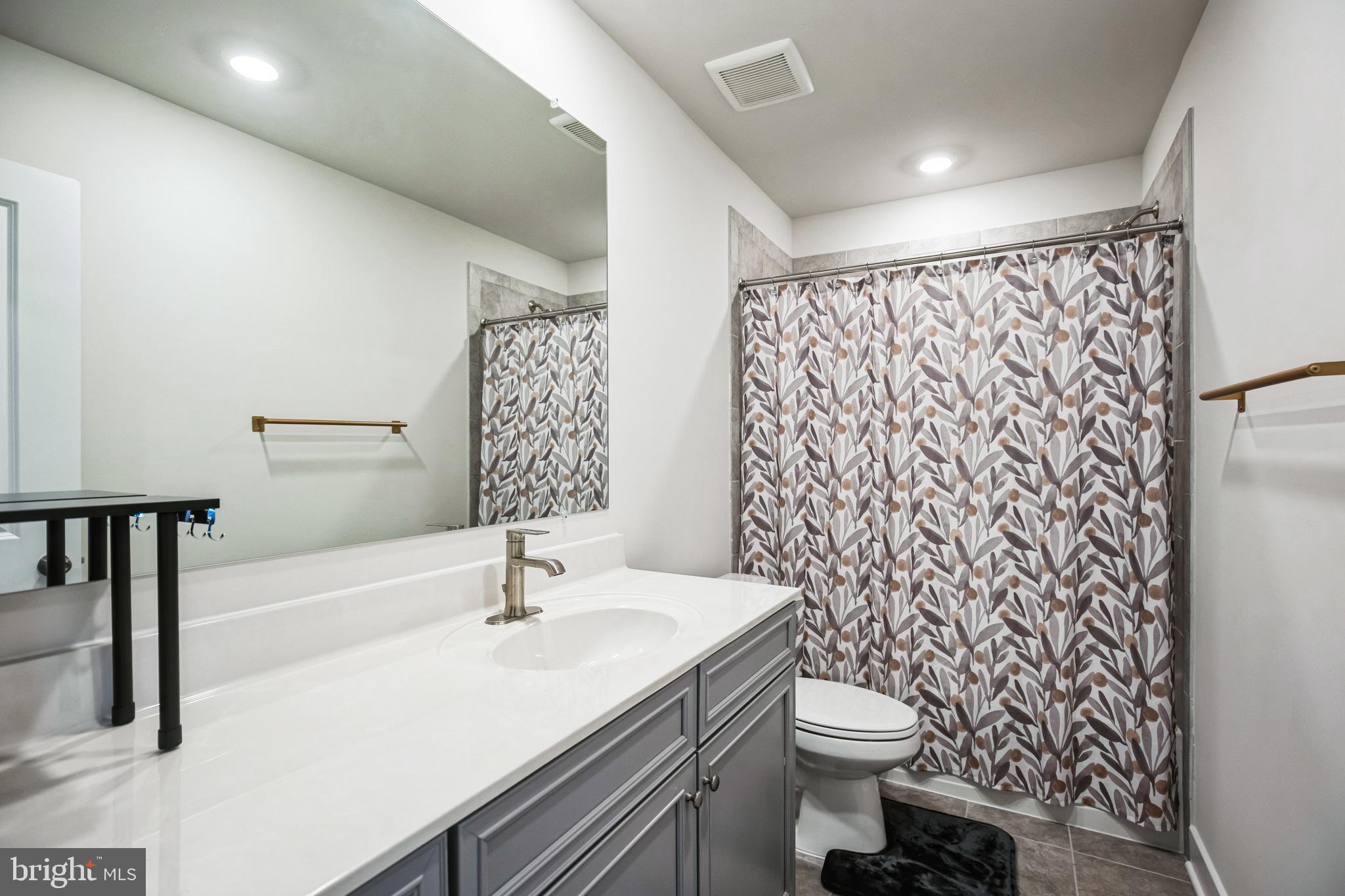 4165 Brodie Place White Plains, MD 20695 - Photo 16 of 28 a bathroom with a sink a toilet and shower curtain