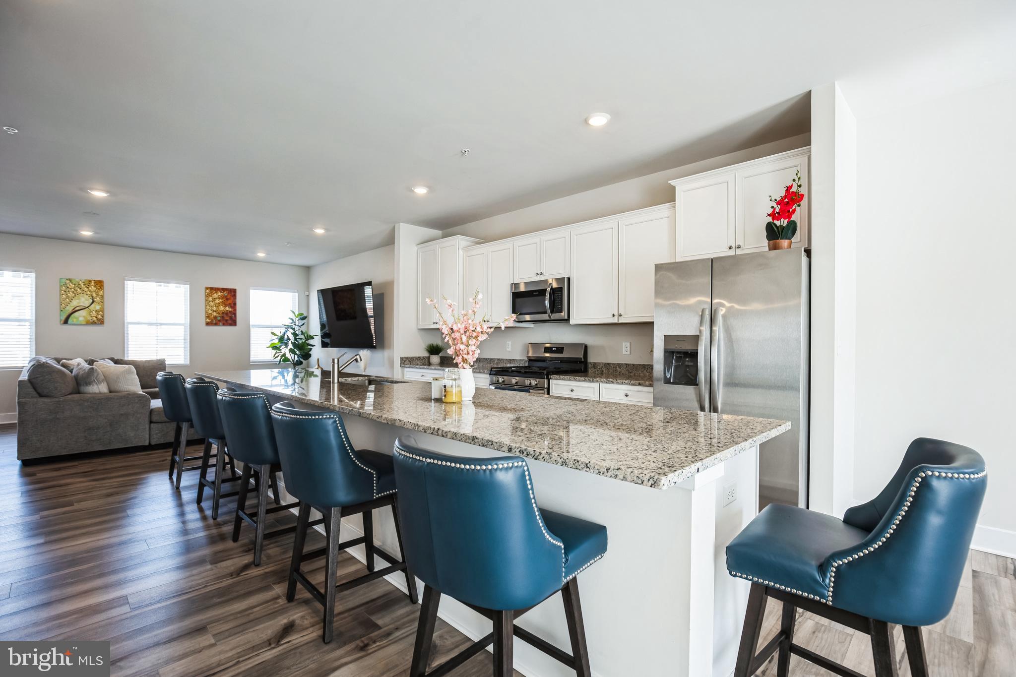 4165 Brodie Place White Plains, MD 20695 - Photo 6 of 28 a kitchen with stainless steel appliances granite countertop a dining table chairs stove refrigerator and cabinets