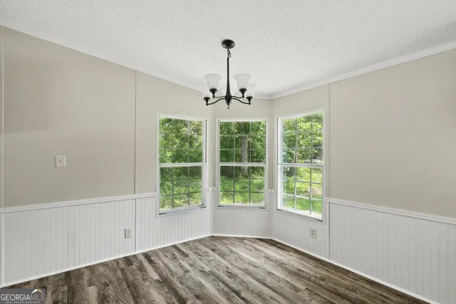 a view of a room with a large window and wooden floor
