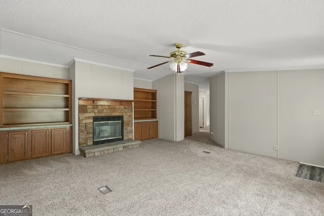 a view of empty room with a fireplace and fan
