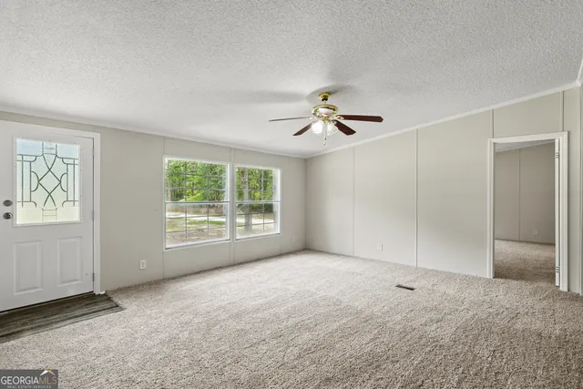 an empty room with closet and a ceiling fan