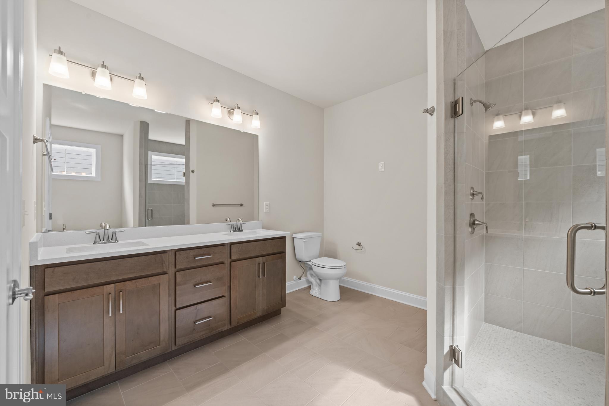 Lot#21 Hummingbird Road Ellendale, DE 19941 - Photo 11 of 66 a spacious bathroom with a double vanity sink toilet mirror and windows