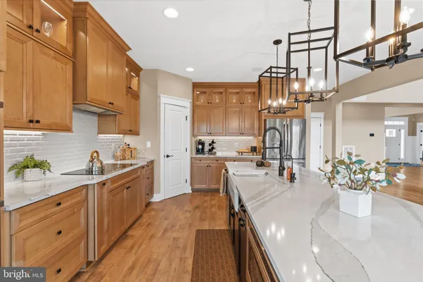 a kitchen with stainless steel appliances a dining table chairs and wooden floor