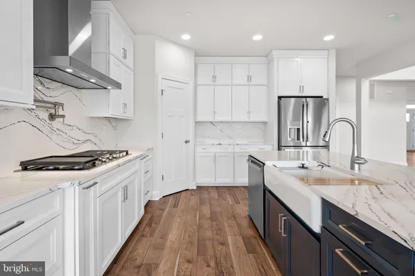 a kitchen with stainless steel appliances granite countertop a refrigerator and a sink