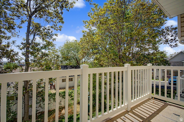 2058 California Avenue, Unit 2 Provo, UT 84606 - Photo 31 of 32 Outdoor balcony featuring white railing, concrete flooring, and mature trees providing natural screening
