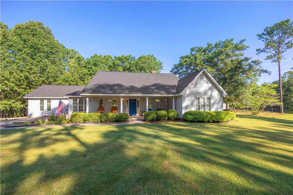 62 McCarthy Road Opelika, AL 36804 - Photo 1 of 74 Light gray siding exterior with a dark shingle roof, featuring a full-width covered front porch with white columns